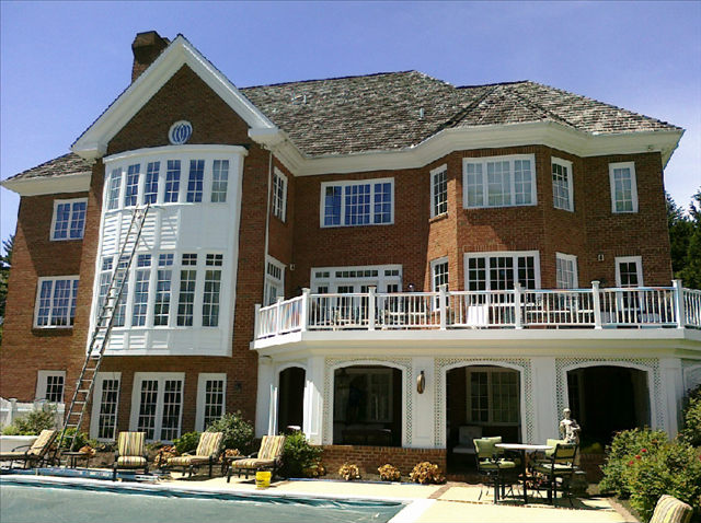 A large brick house with a pool in the back yard.