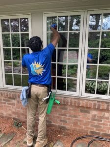 A Man Cleaning the Windows Outside a House