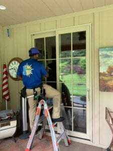 A Man in a Blue Color Top Cleaning a Window
